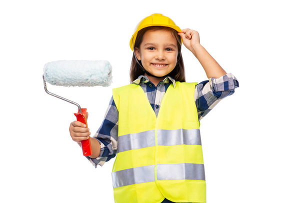 girl in helmet and safety vest with paint roller - Zdjęcie, obraz