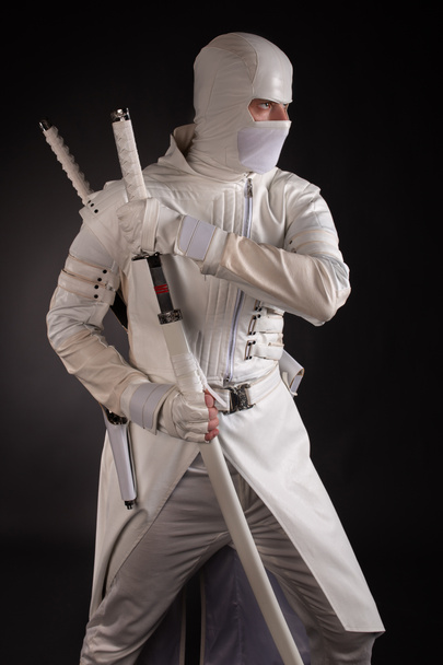 man in white ninja clothes in the studio on a black background - Foto, imagen