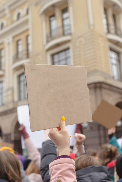Γυναίκα κρατά αφίσα στο χέρι της με φόντο τη φεμινιστική διαμαρτυρία. Αντιγραφή χώρου. - Φωτογραφία, εικόνα