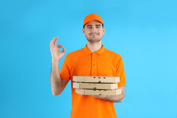 Toimittaja pitää pizzaa sinisellä taustalla - Valokuva, kuva