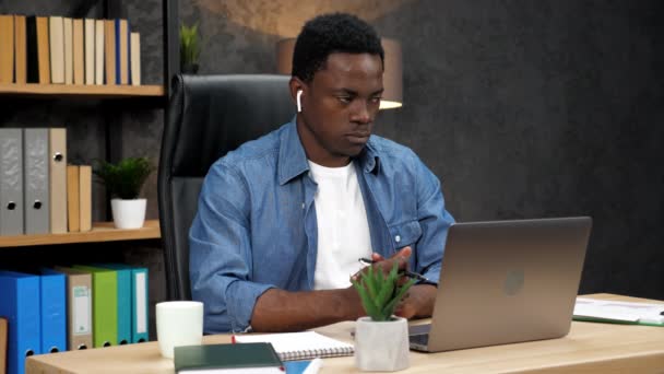 Hombre de negocios afroamericano escucha a los empleados en línea reunión de videollamada portátil - Metraje, vídeo