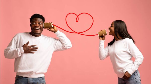 Feliz afro-americanos amantes falando através lata telefone - Foto, Imagem