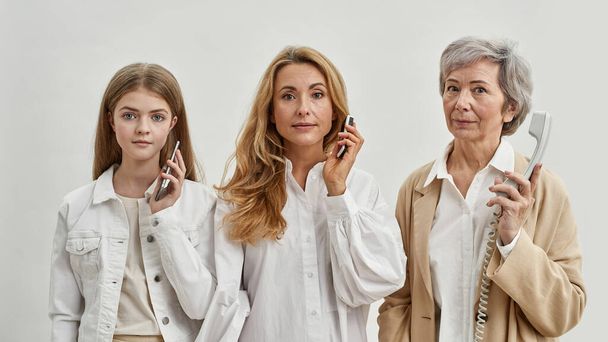 Family of three females with different phones - Zdjęcie, obraz