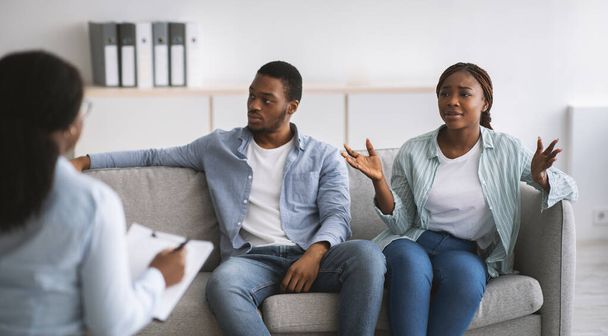Жінка-психолог дає сеанс терапії підкресленим молодим чорношкірим пара в офісі, панорама
 - Фото, зображення