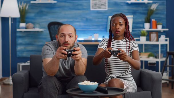 Modern interracial couple playing video game on TV - Photo, Image