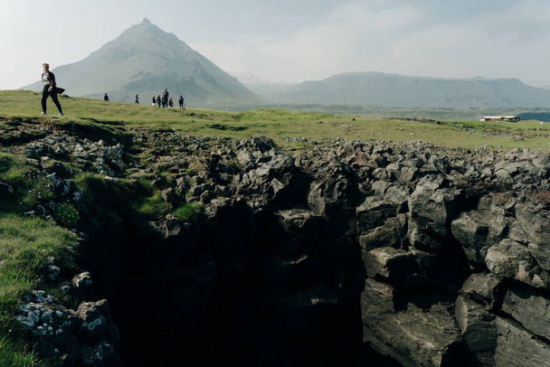 Campo con un villaggio alla base del picco vulcanico di Gatklettur. . Foto di alta qualità - Foto, immagini