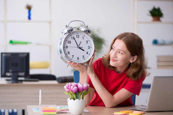 Young female designer in time management concept - Photo, Image