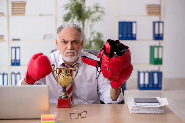 Old male employee boxer being awarded with golden cup - Photo, Image