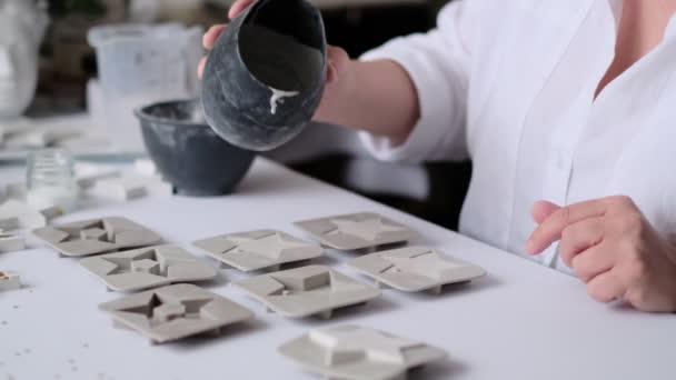 mujer artesana vierte la mezcla de yeso en moldes de silicona. creatividad y autorrealización de una mujer moderna - Metraje, vídeo