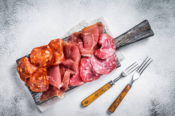 Antipasti di carne assortiti - salame, marmellata, salsicce choriso. Sfondo bianco. Vista dall'alto - Foto, immagini