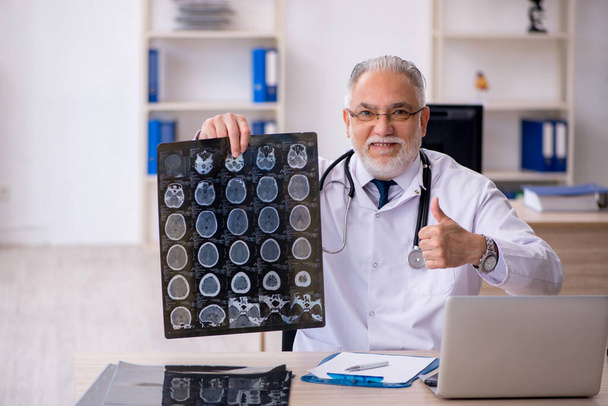 Oude mannelijke arts radioloog werkzaam in de kliniek - Foto, afbeelding