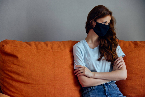woman in black medical masks lockdown at home on the couch stay home concept - Photo, Image