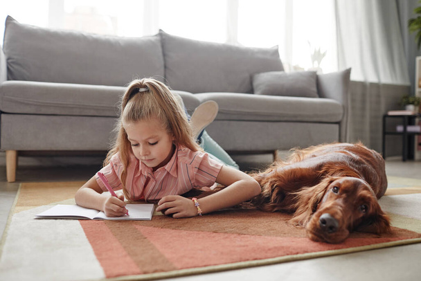 Girl Drawing with Big Dog at Home - Foto, imagen