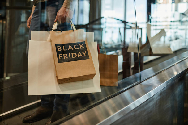 Man Holding Black Friday Shopping Bags - Foto, afbeelding
