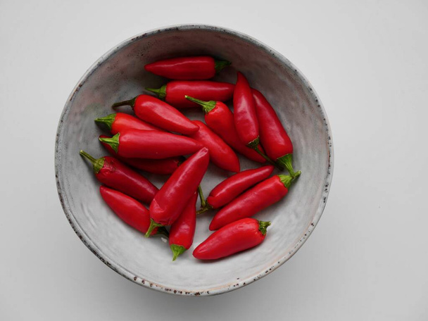 Ilmakuva punaisesta chilistä pohjoismaisella keraamisella lautasella. - Valokuva, kuva