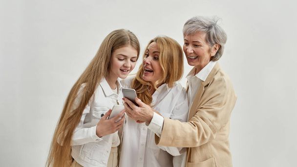 Pleased females watching smartphones of each other - Zdjęcie, obraz