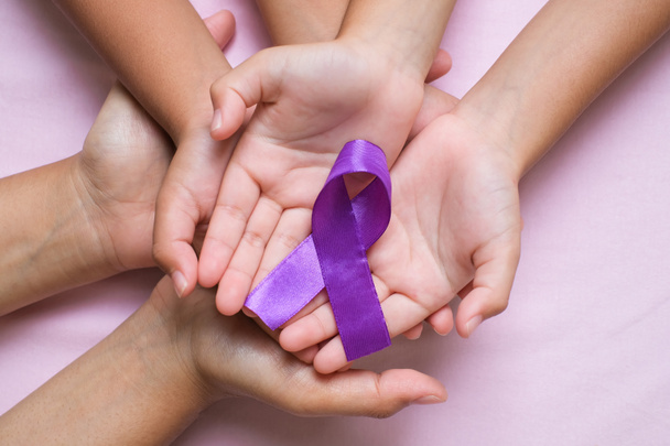 Hands holding Purple ribbons world cancer day concept, Alzheimer disease, Pancreatic cancer, Epilepsy awareness, domestic violence awareness, fibromyalgia awareness - Zdjęcie, obraz