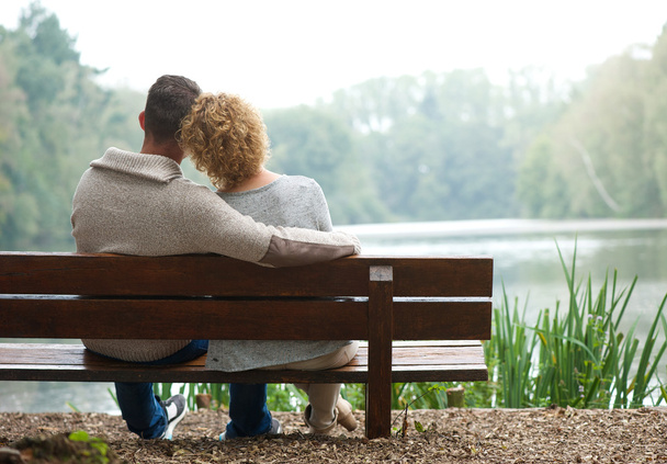 Rear view couple sitting on bench outdoors - Φωτογραφία, εικόνα