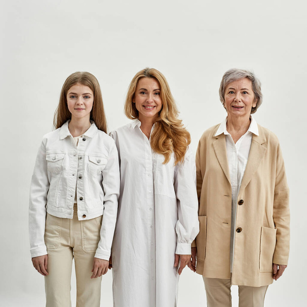 Family of three female generations look at camera - Фото, изображение