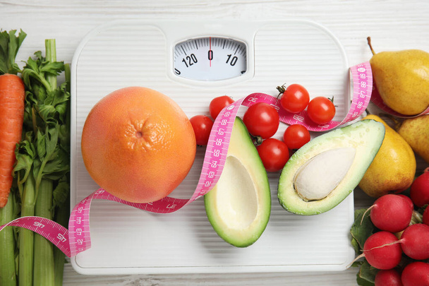 Flat lay composition with scales and healthy food on white wooden table - Foto, Bild