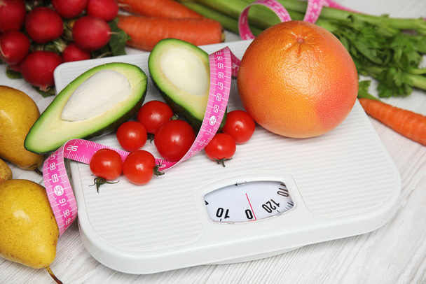 Scales, healthy food and measuring tape on white wooden table - 写真・画像