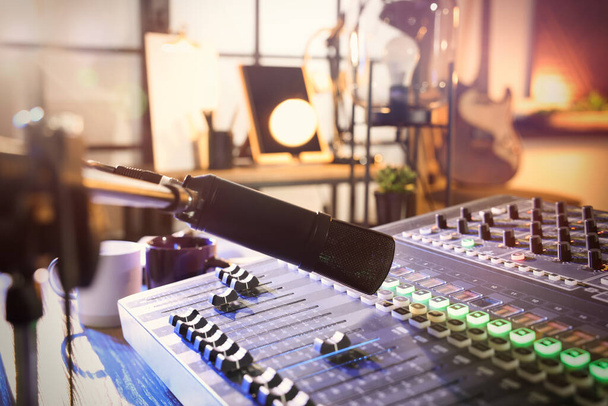 Microphone over professional mixing console on table in radio studio - Foto, imagen