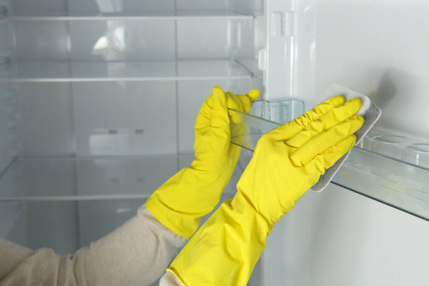 Bir kadın buzdolabını dezenfektanlarla yıkıyor.. - Fotoğraf, Görsel