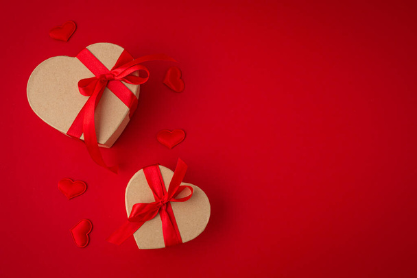 Deux boîtes-cadeaux enveloppées en forme de coeur sur fond rouge, Saint Valentin - Photo, image