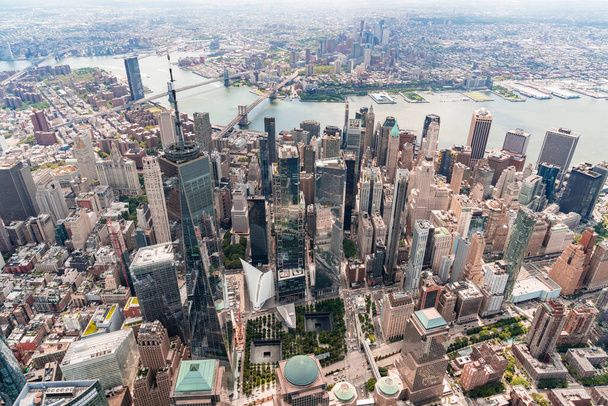 Aerial city view on Lower Manhattan area. Brooklyn and Manhattan bridges over East River, New York City, USA. Birds eye view from helicopter of metropolis cityscape. A vibrant business neighborhood. - 写真・画像