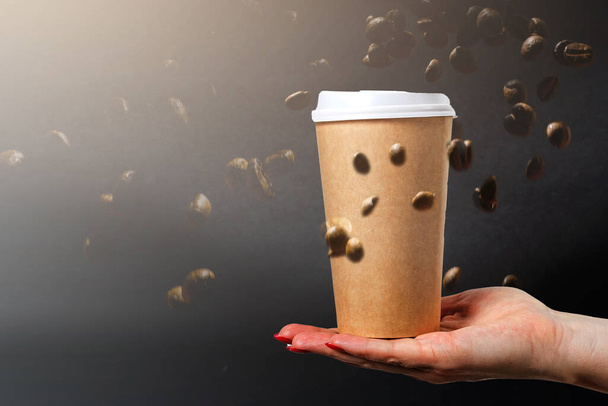Tazas de papel café con granos de café sobre un fondo oscuro. Patrón y concepto de fondo creativo para cafeterías. - Foto, Imagen