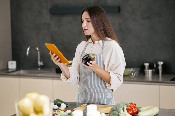 Young housewife looking for new cooking ideas on internet - Zdjęcie, obraz