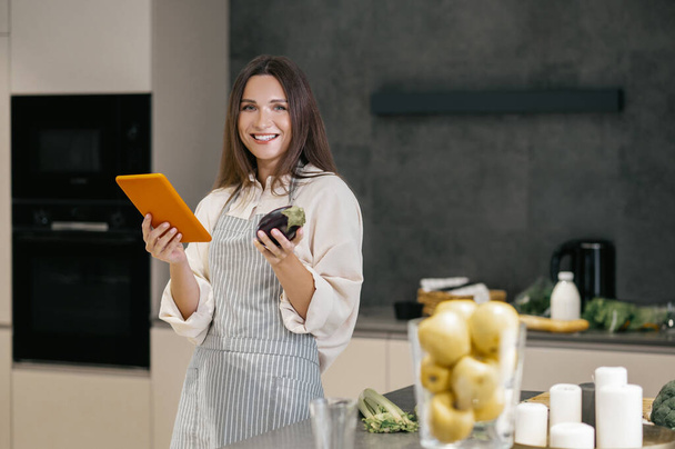 Long-haired young woman thinking about cooking something for lunch - Photo, Image