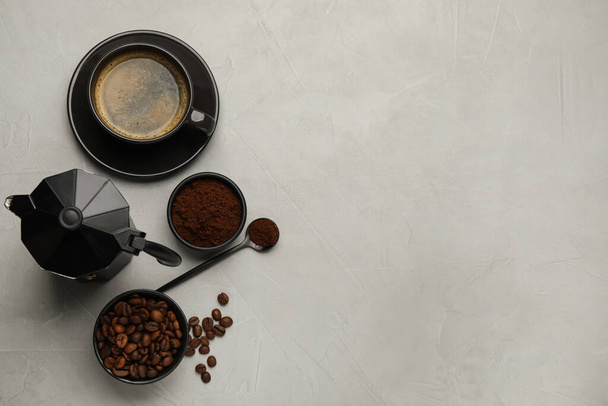 Flat lay composition with coffee grounds and roasted beans on light table, space for text - Foto, Bild