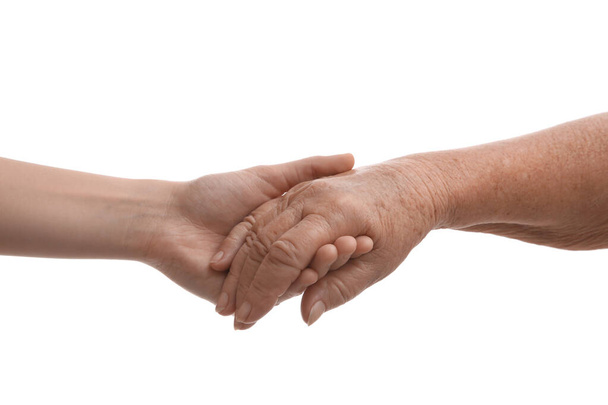Young and elderly women holding hands together on white background, closeup - Fotografie, Obrázek