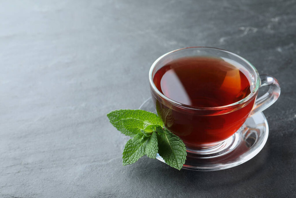Cup of hot aromatic tea with mint on grey table. Space for text - Foto, imagen