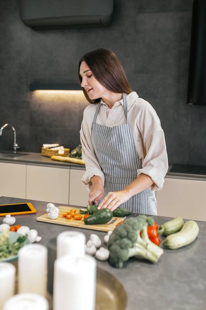 Long-haired young housewife cooking in the kitchen - 写真・画像