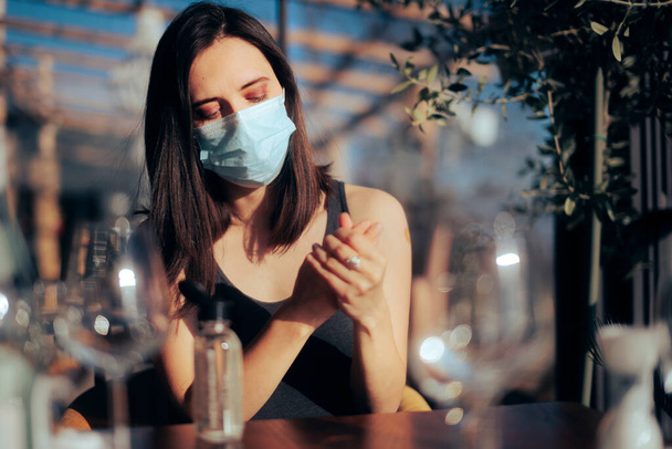 Woman Using Hand Sanitizer and Face mask in a Restaurant - Foto, Imagem