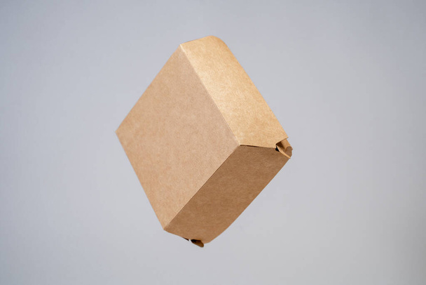 cardboard craft packaging for food hanging in air on white isolated background - Fotoğraf, Görsel
