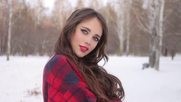Kobieta z czerwonymi ustami w zimowym lesie - Materiał filmowy, wideo