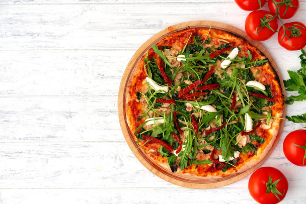 Fresh pizza with herbs and sun dried tomatoes on gray table - Foto, Imagem