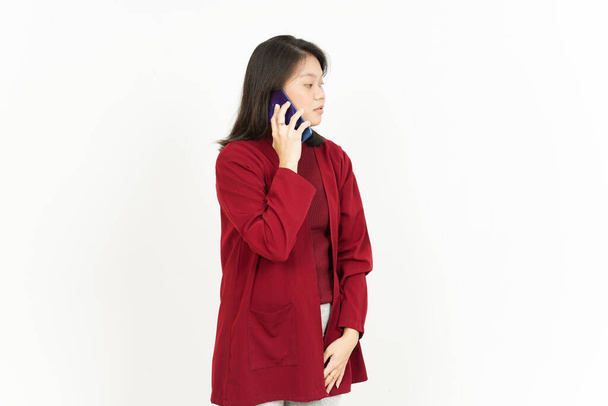 Beszélgetés a telefon gyönyörű ázsiai nő viselő piros ing elszigetelt fehér háttér - Fotó, kép
