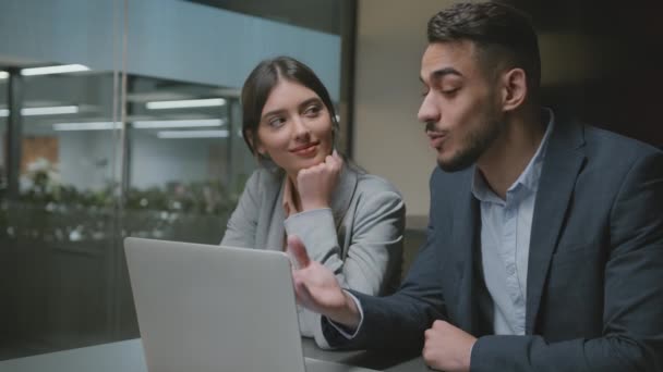 Szerelem a munkahelyen. Fiatal nő néz a jóképű arab kollégája és mosolygós, elfoglalt férfi elmagyarázza projekt laptop - Felvétel, videó