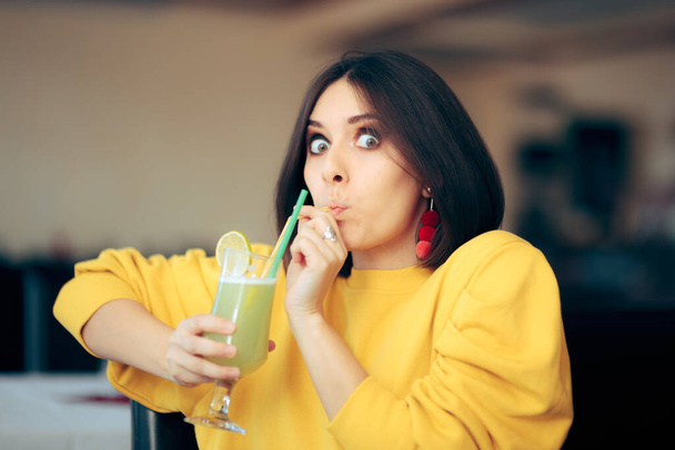 Cheerful Woman Sipping Lemonade Drink with a Straw - 写真・画像