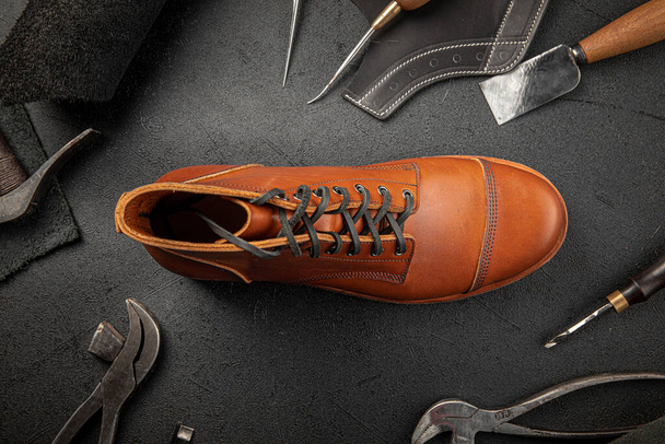Chaussure artisanale en cuir marron avec des outils de cordonnier - Photo, image
