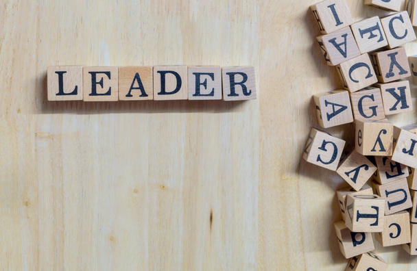 Myšlenka konceptu Leader, dřevěná písmena navazující na poselství na dřevěném stole, informace a komunikace o vedoucích představitelích myšlení, práce, iniciativy nebo učení se k úspěchu, na špičkovém a kopírovacím prostoru - Fotografie, Obrázek