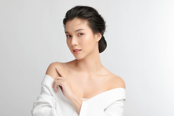 Mooie jonge Aziatische vrouw met badjas op witte achtergrond, Gezichtsverzorging, Gezichtsbehandeling, Cosmetologie, schoonheid en spa Concept. - Foto, afbeelding