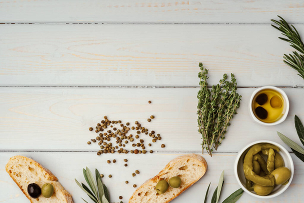 Italian ciabatta bread with olive oil on wooden background - Foto, afbeelding