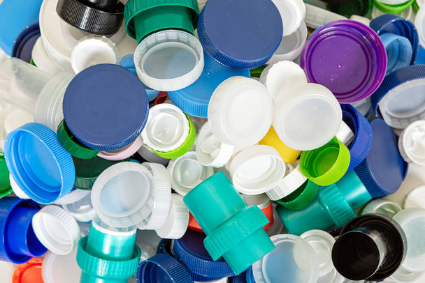 Вид сверху на весь рамочный фон разноцветных пластиковых колпачков, подготовленных к переработке - Фото, изображение