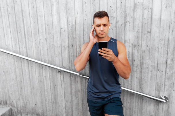 young athlete man with earphones and smartphone - Фото, изображение