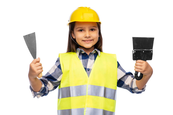 girl in helmet and safety vest with spatulas - Фото, зображення